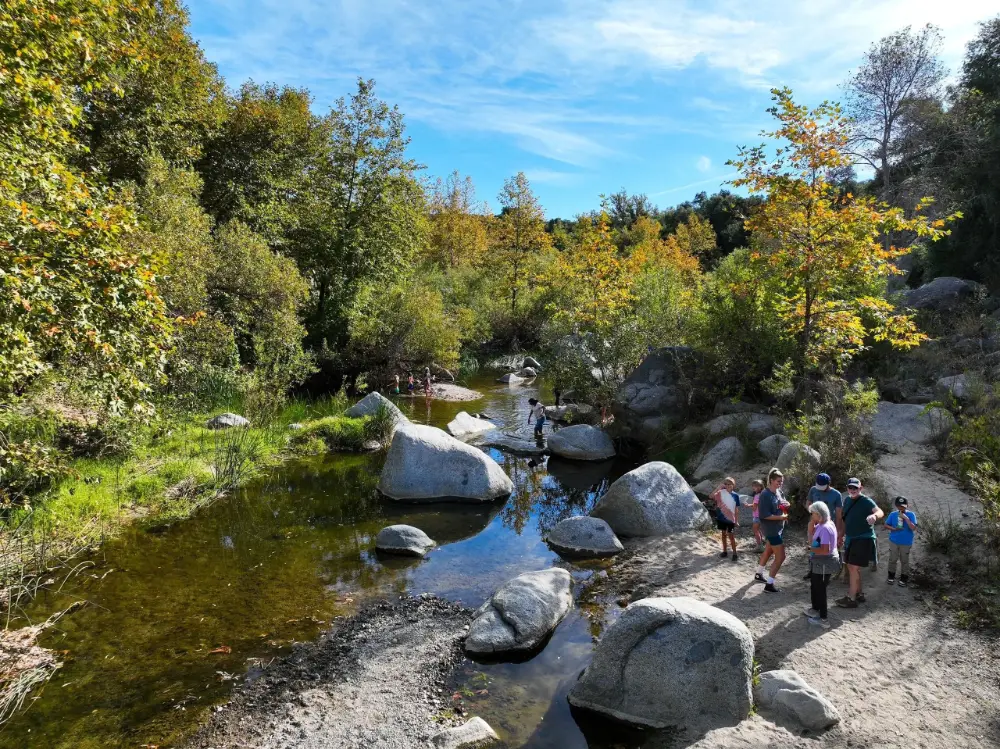 Hikers crossing the boulders of the Santa Margarita River